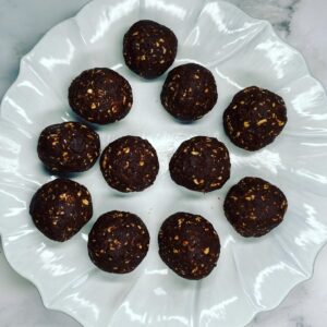 11 Double Chocolate Peanut Butter Bliss Balls served on a white plate.